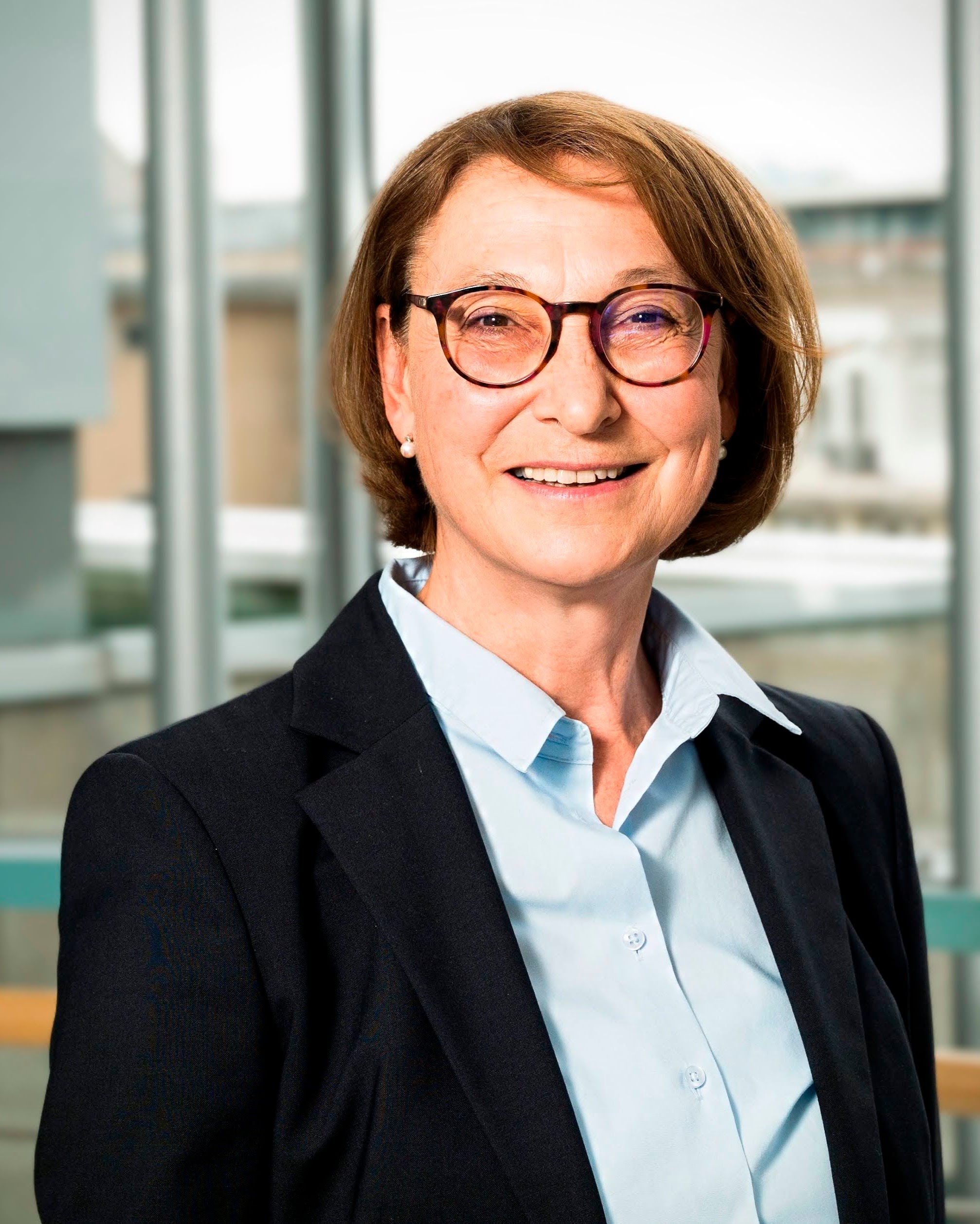 Portr&auml;tfoto einer Person in Business-Kleidung in einem hellen B&uuml;ro