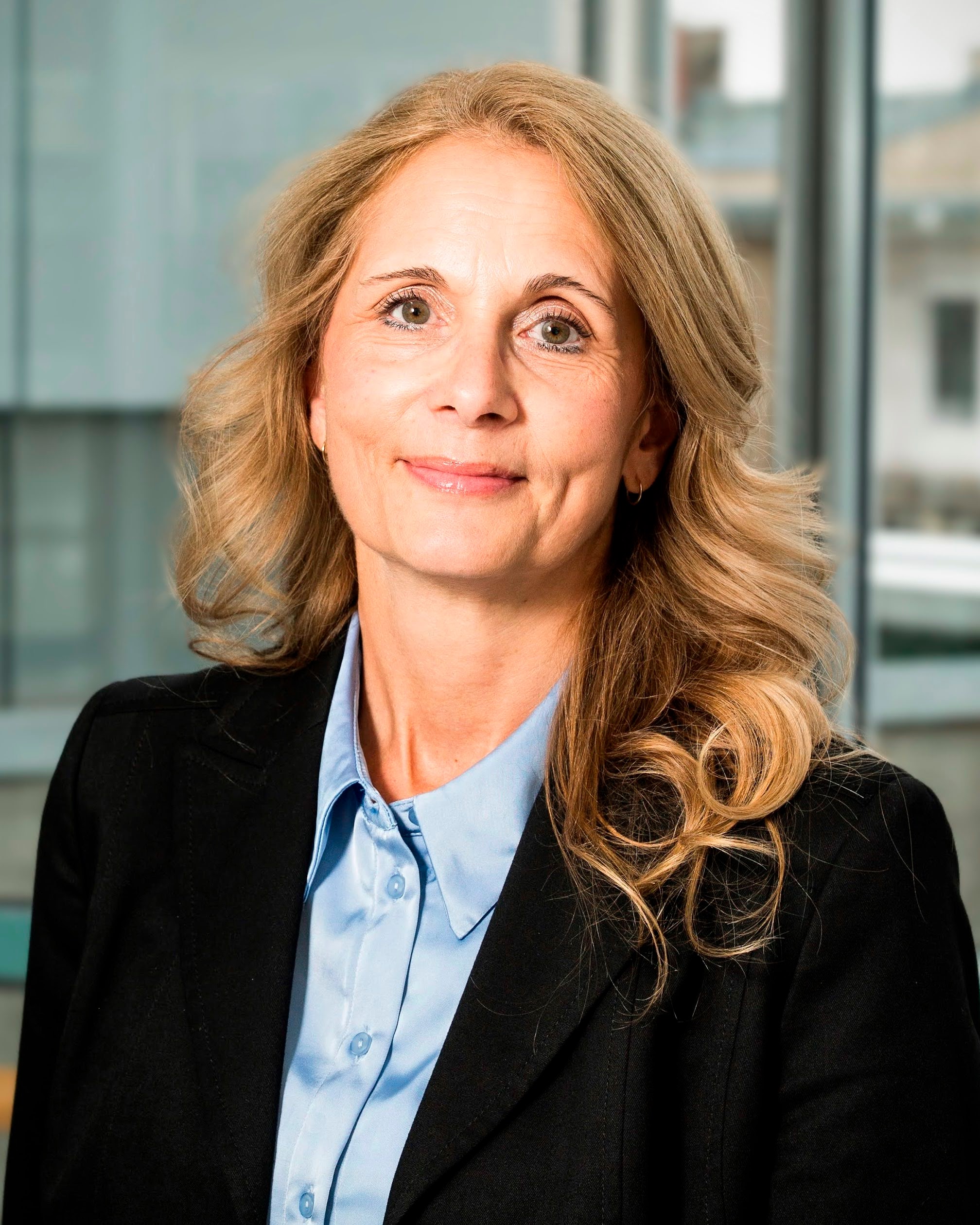 Portr&auml;tfoto einer Person in Business-Kleidung in einem hellen B&uuml;ro