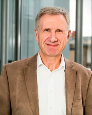 Portr&auml;tfoto eines Gesch&auml;ftsf&uuml;hrers in Business-Kleidung in einem hellen B&uuml;ro